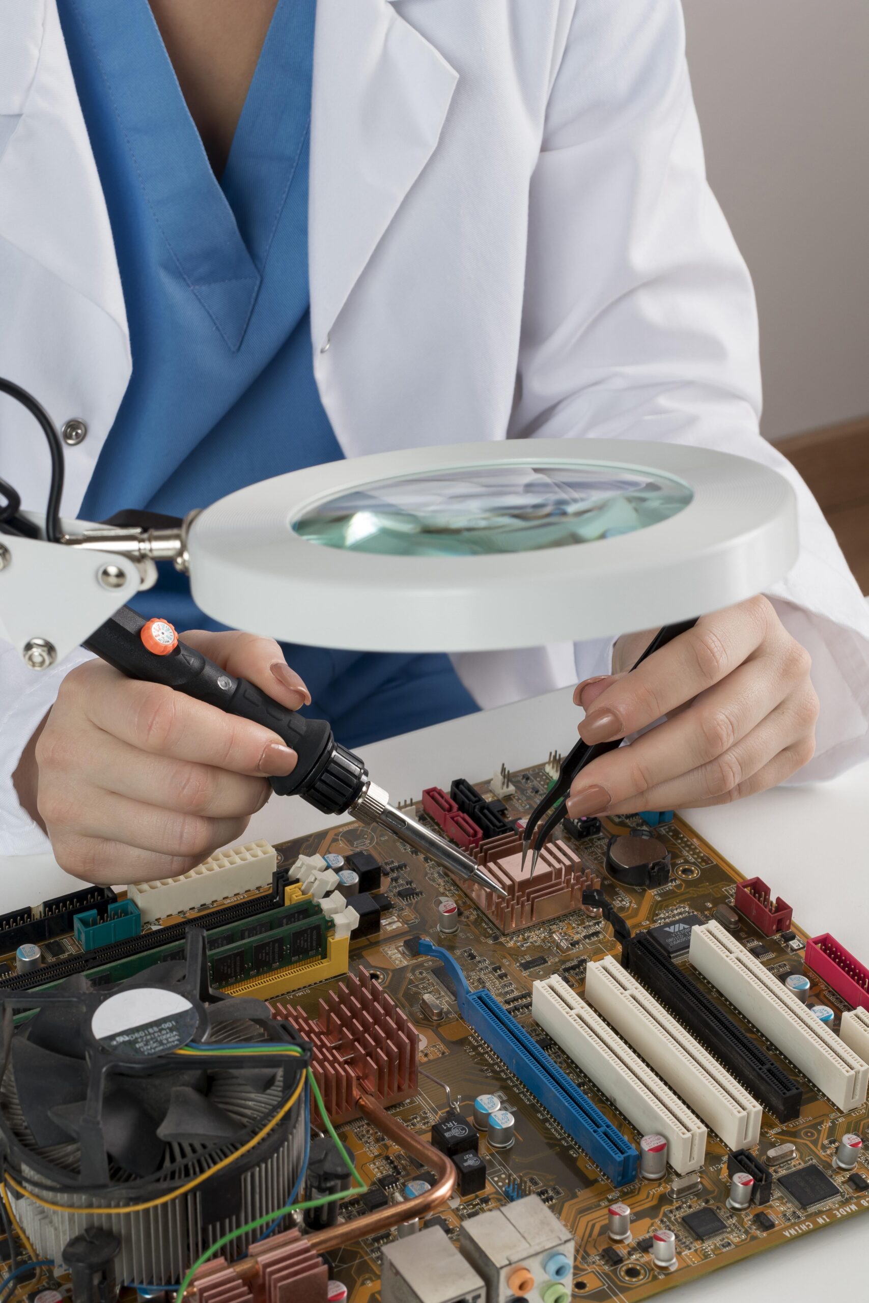 personne avec blouse blanche qui travaille sur de l'électronique